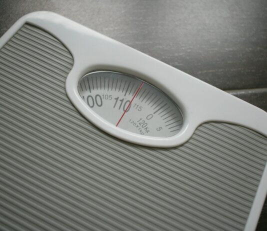 다이어트와 운동: 건강을 위한 동반자로서의 역할 a bathroom scale sitting on top of a wooden table