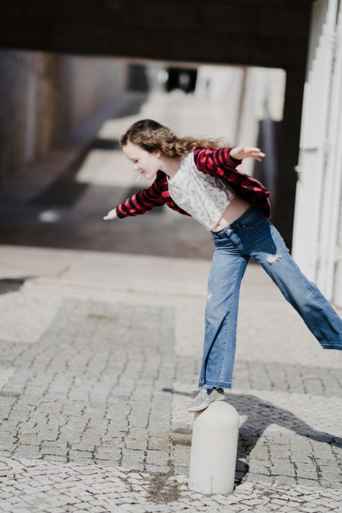 Photo by Annie Spratt girl balancing on top of concrete stand
