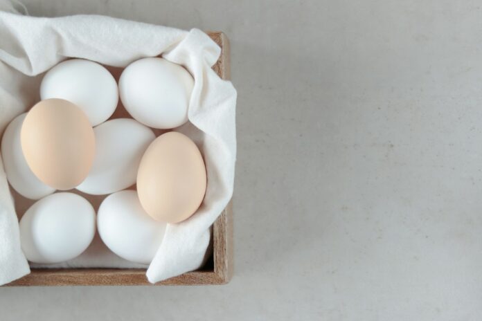 Photo by Olga Petnyunene a wooden box filled with eggs on top of a table