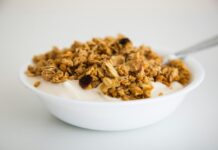 운동 후 빠른 회복을 돕는 식단 계획 a bowl of granola and yogurt with a spoon