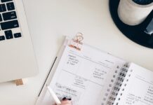 자기계발을 위한 일일 계획 작성법 person holding notepad and pen flat lay photography