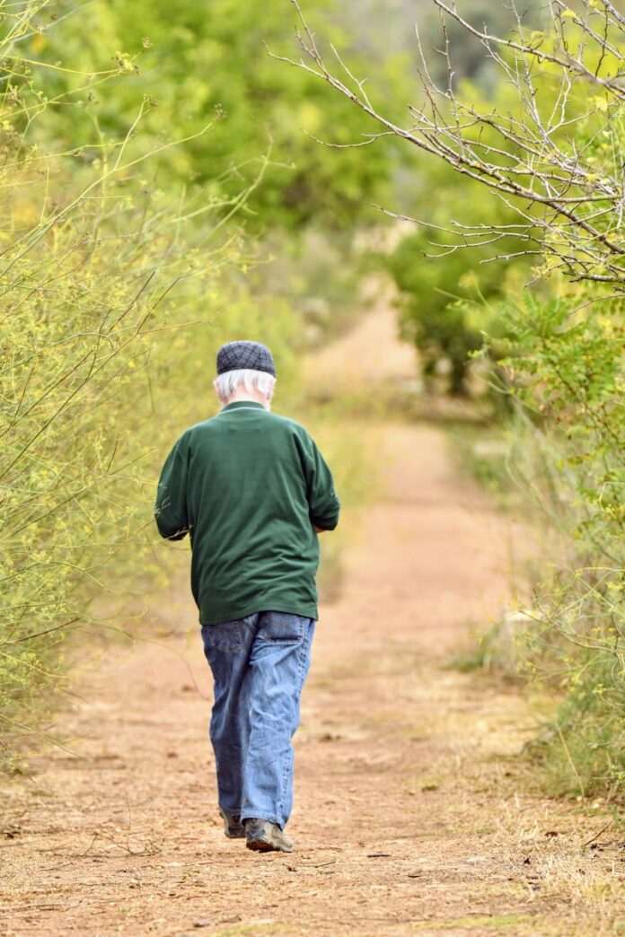 Photo by shraga kopstein a man walking on a dirt path