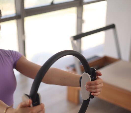 필라테스, 몸과 마음을 깨우는 건강한 움직임의 시작 a woman sitting on the floor holding a steering wheel