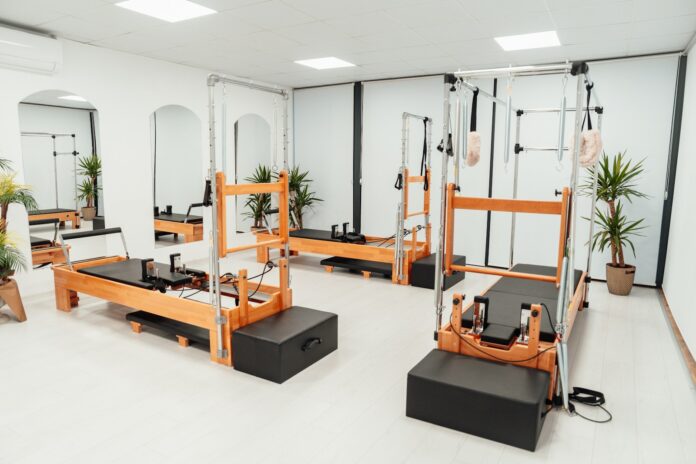 Photo by Ahmet Kurt a gym with a row of machines and mirrors
