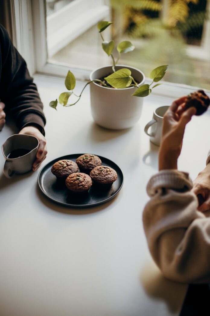 Photo by Priscilla Du Preez 🇨🇦 person holding brown and black round food on white ceramic plate