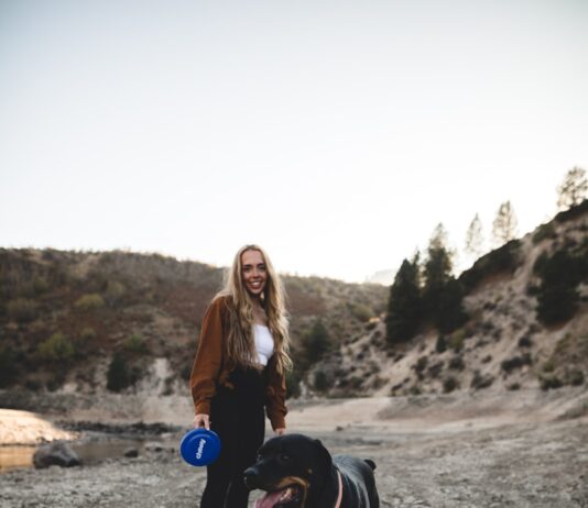 반려견과의 산책은 요가다: 서로의 보폭을 맞추는 치유의 시간 woman in black t-shirt holding blue and white ball