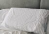 “수면부터 달라진다”…새롭게 떠오르는 ‘슬리핑 루틴’ 실천 열풍 A rumpled white duvet and pillows on a bed.