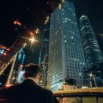“현대인의 스트레스, 일상 속 작은 습관으로 건강하게 관리한다” Man in suit enters taxi with city skyscrapers at night