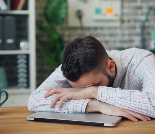 만성피로, ‘휴식 습관’이 해답… 일상에서 실천하는 에너지 회복법 a man sitting at a desk with his head in his hands