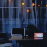 “마음에도 휴식이 필요해요”… 실천 가능한 정신건강 트렌드와 생활 속 루틴 Desk with tablet, book, and digital clock at night.