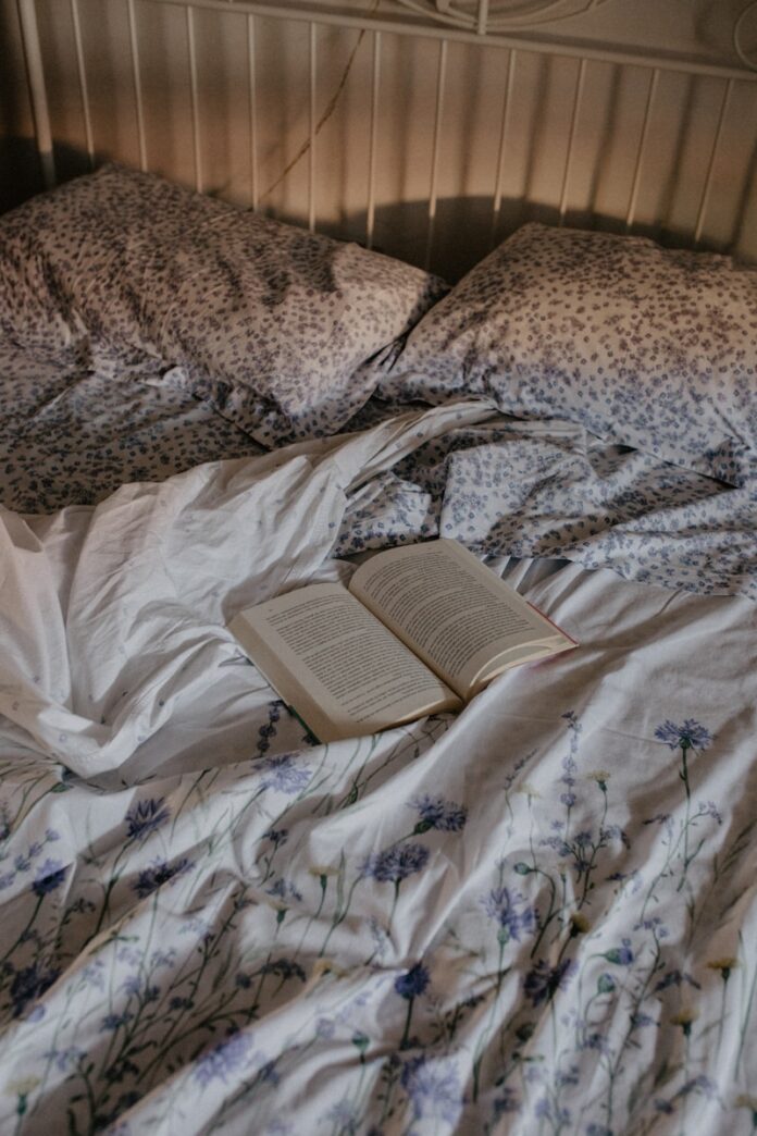 an open book is laying on a messy bed